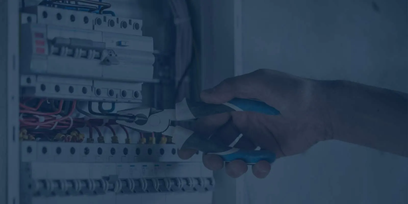 Electricista trabajando con pinza en un tablero eléctrico domiciliario en Rosario